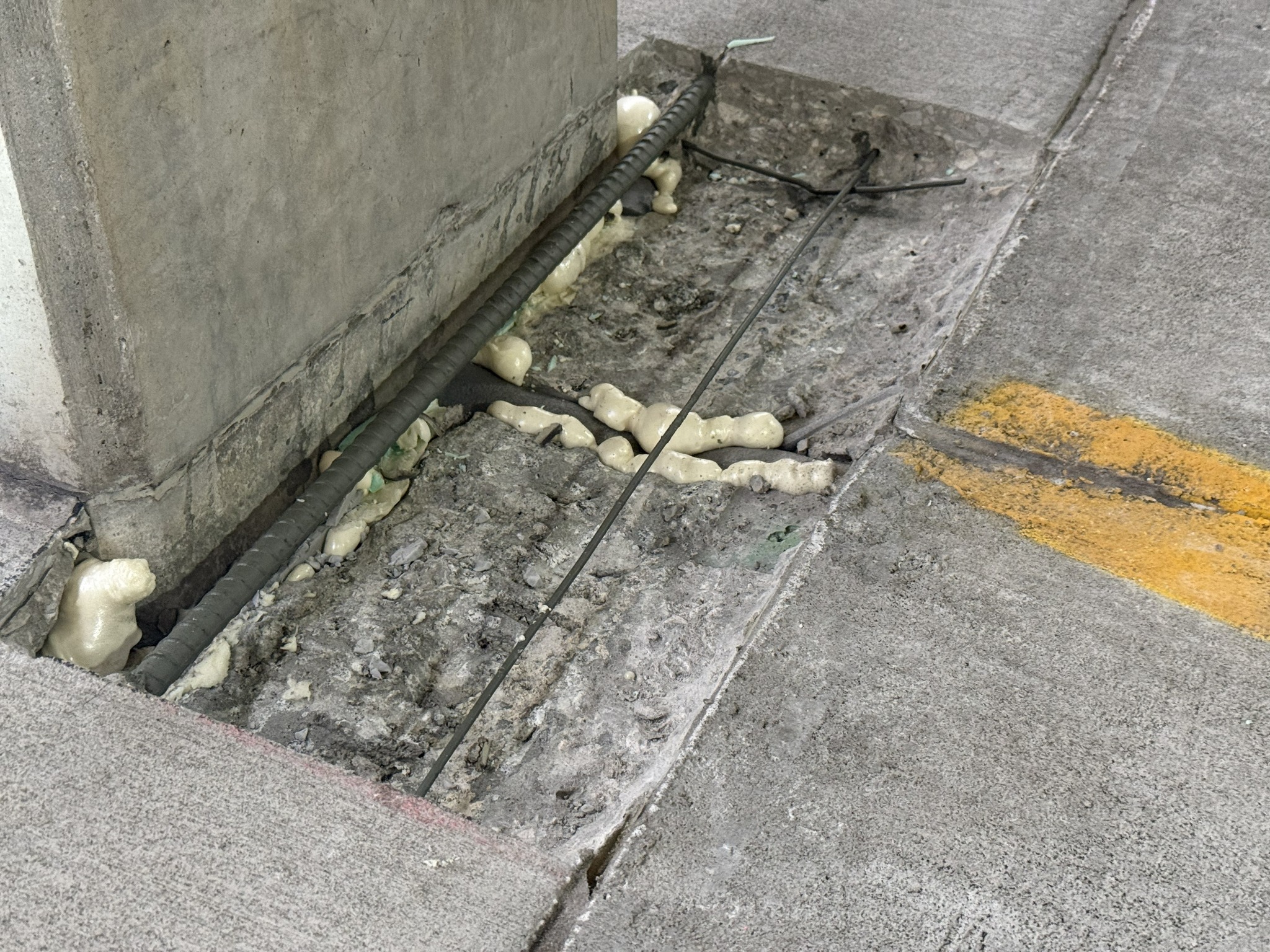 Concrete repair area at parking garage column base with reinforcing steel exposed