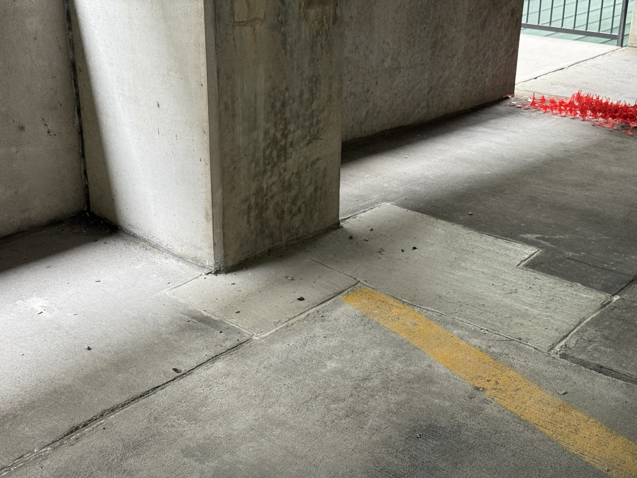 Completed concrete floor slab patch repairs around a parking garage column base
